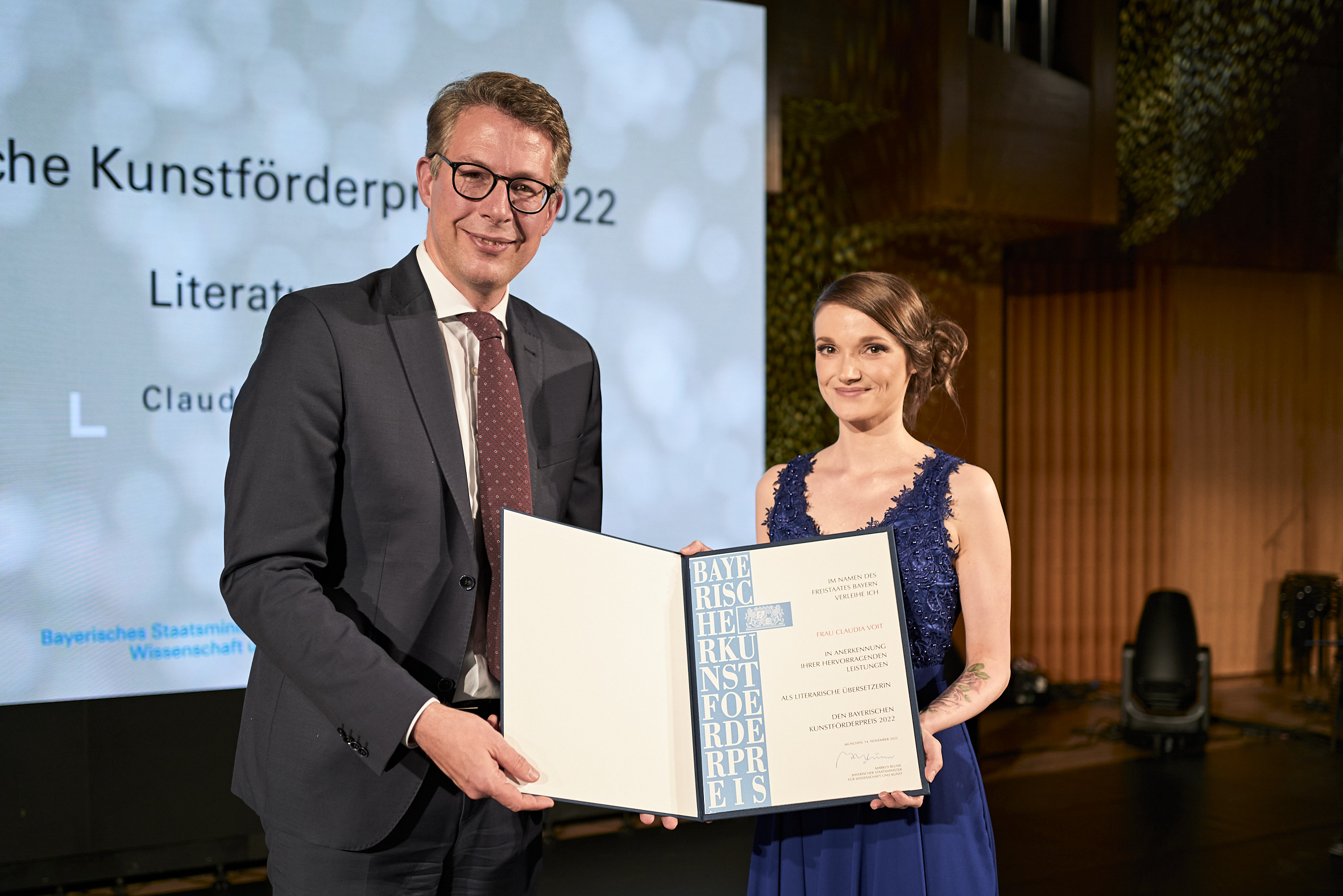 Die Übersetzerin Claudia Voit bekommt den Bayerischen Kunstförderpreis 2022 von Kunstminister Markus Blume verliehen